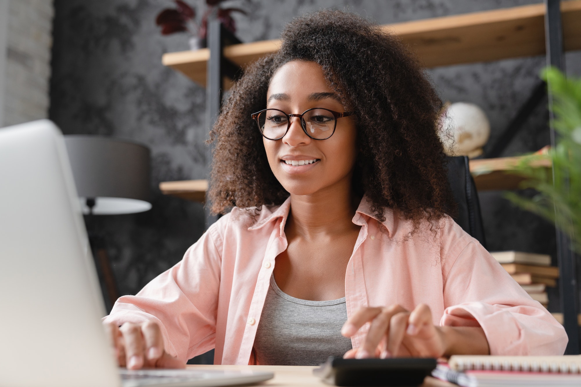 Businesswoman freelancer counting funds domestic bills on calculator using laptop for e-banking